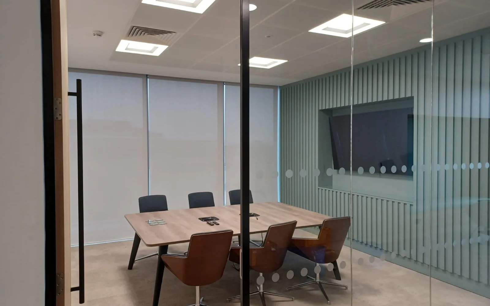 Floor-to-ceiling roller blinds in metallic-backed screen fabric